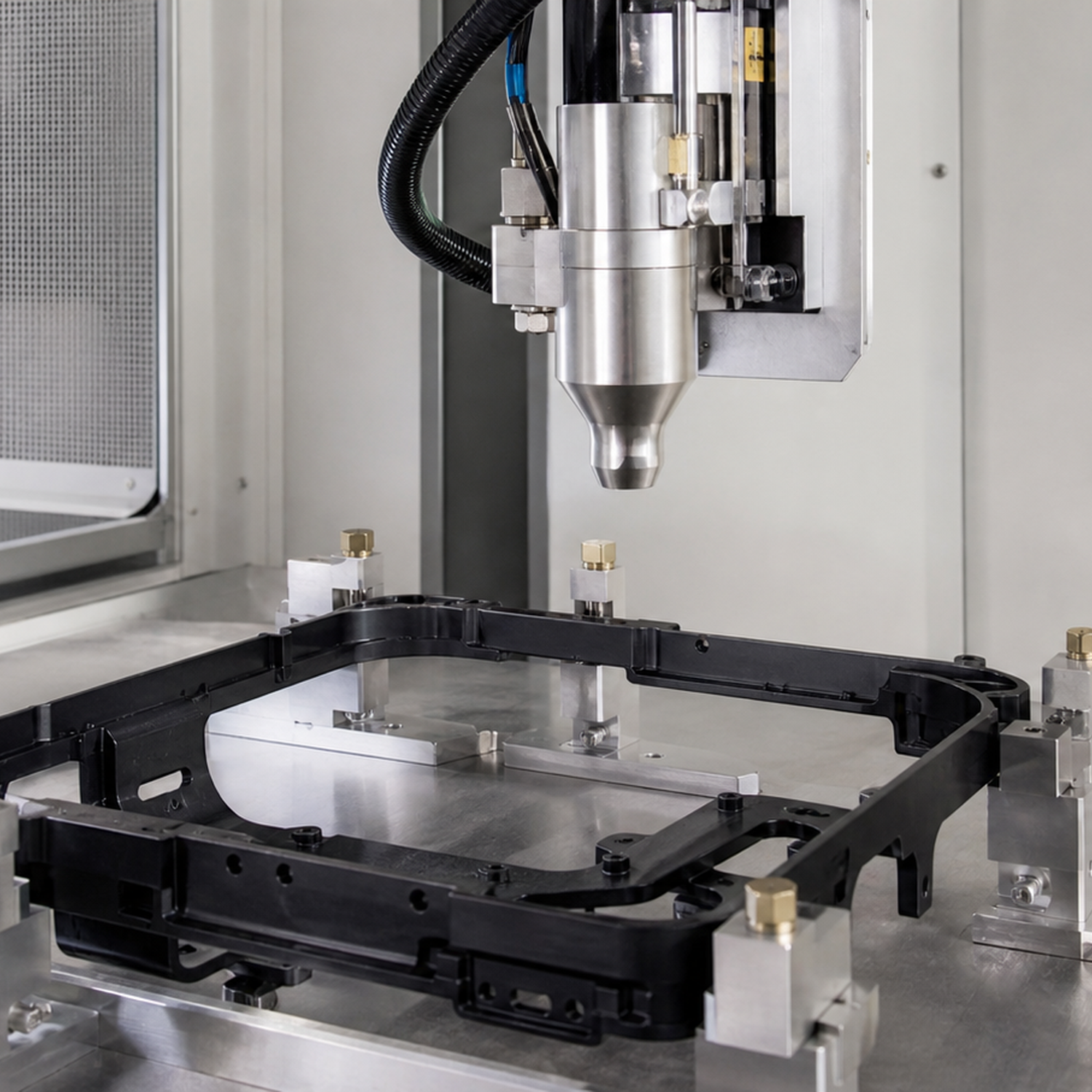 Precision machine nozzle above black frame in industrial lab