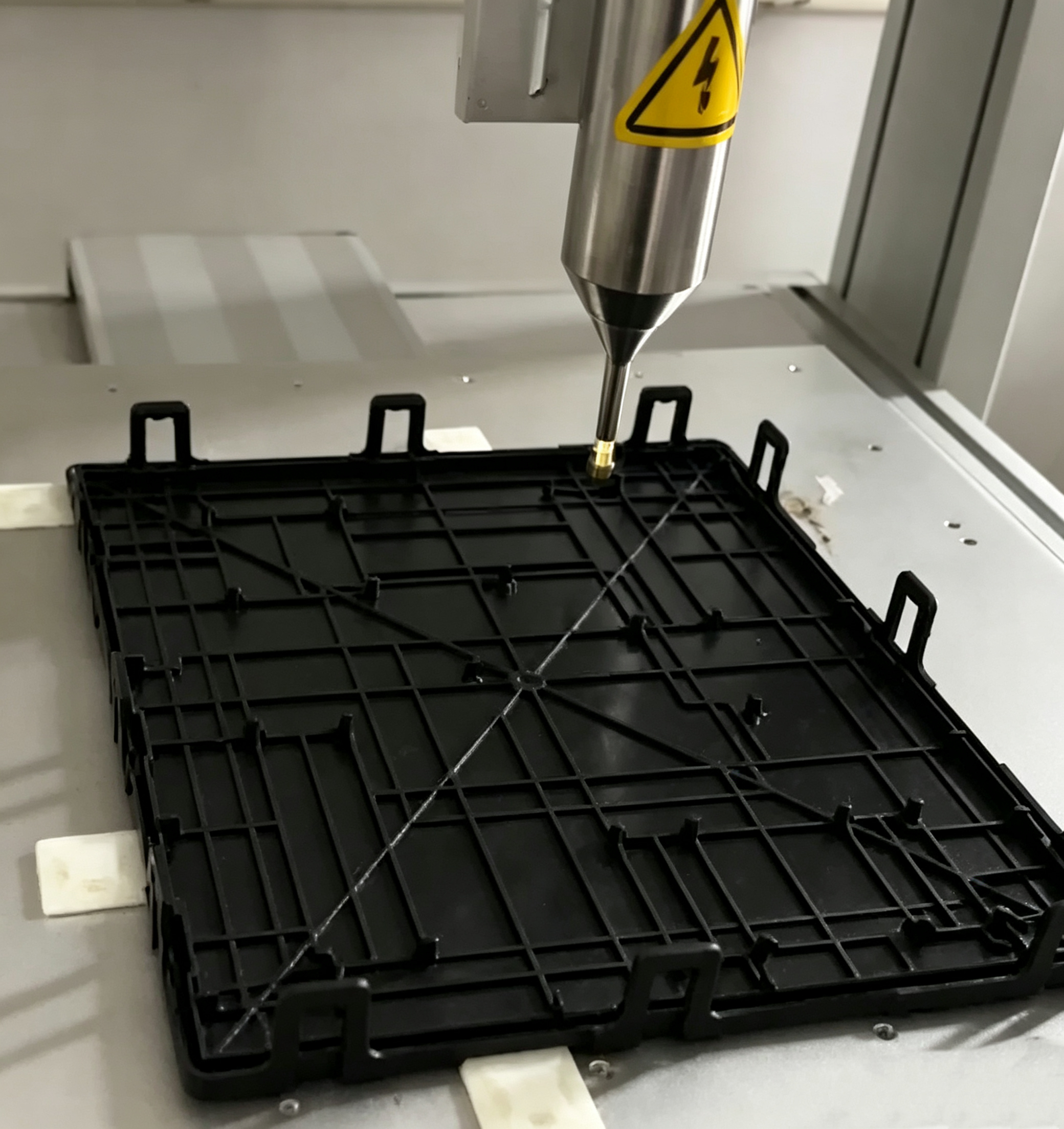 Automotive plastic part mounted in a fixture for plasma surface treatment
