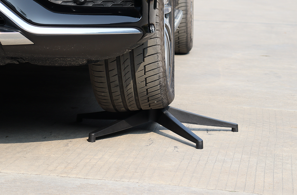 A car driving over a VASEAT chair base to demonstrate base strength
